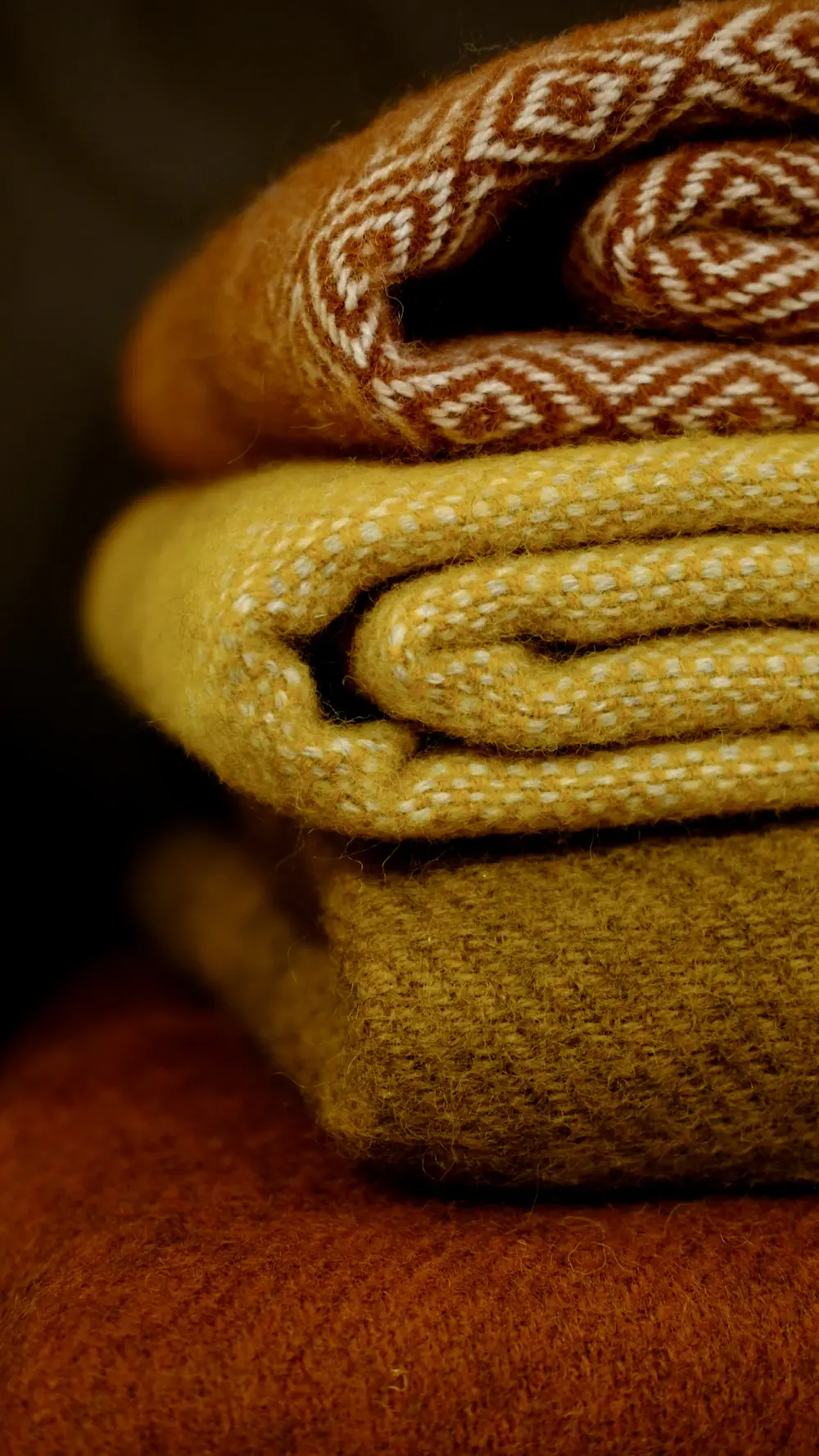 Folded wool throws in mustard and rust