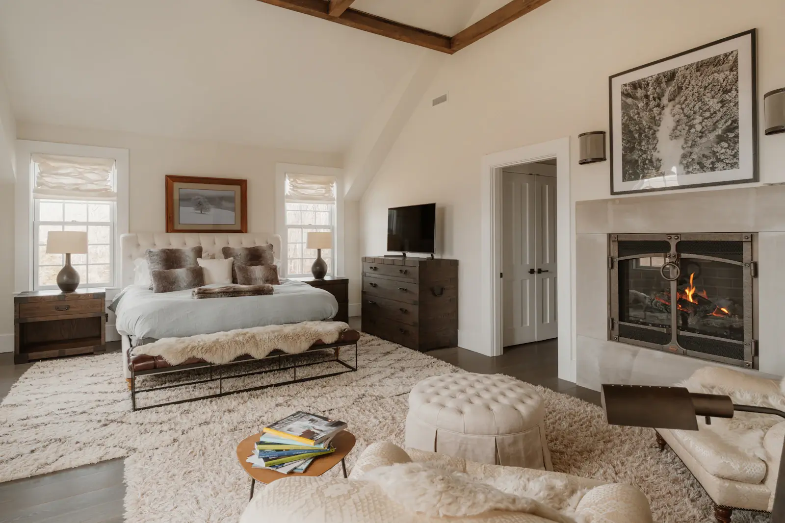 A calm bedroom with a fireplace and layered wool rugs
