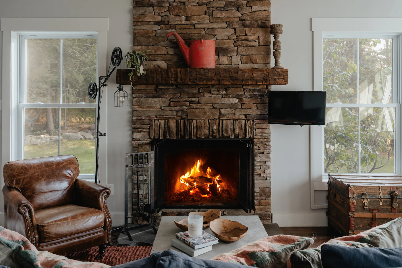 A leather armchair beside a stone fireplace
