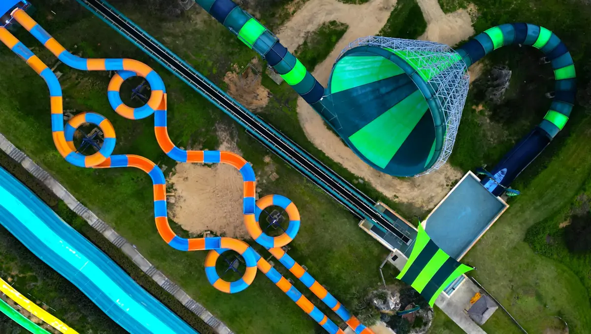 Aerial view of colorful water slides winding across the grass